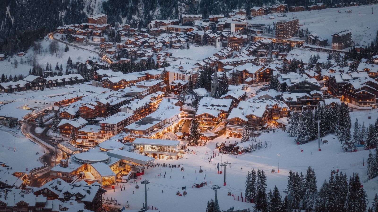 Courchevel 1850 vu des hauteurs à la tombée du jour, fenêtres et vitrines éclairées