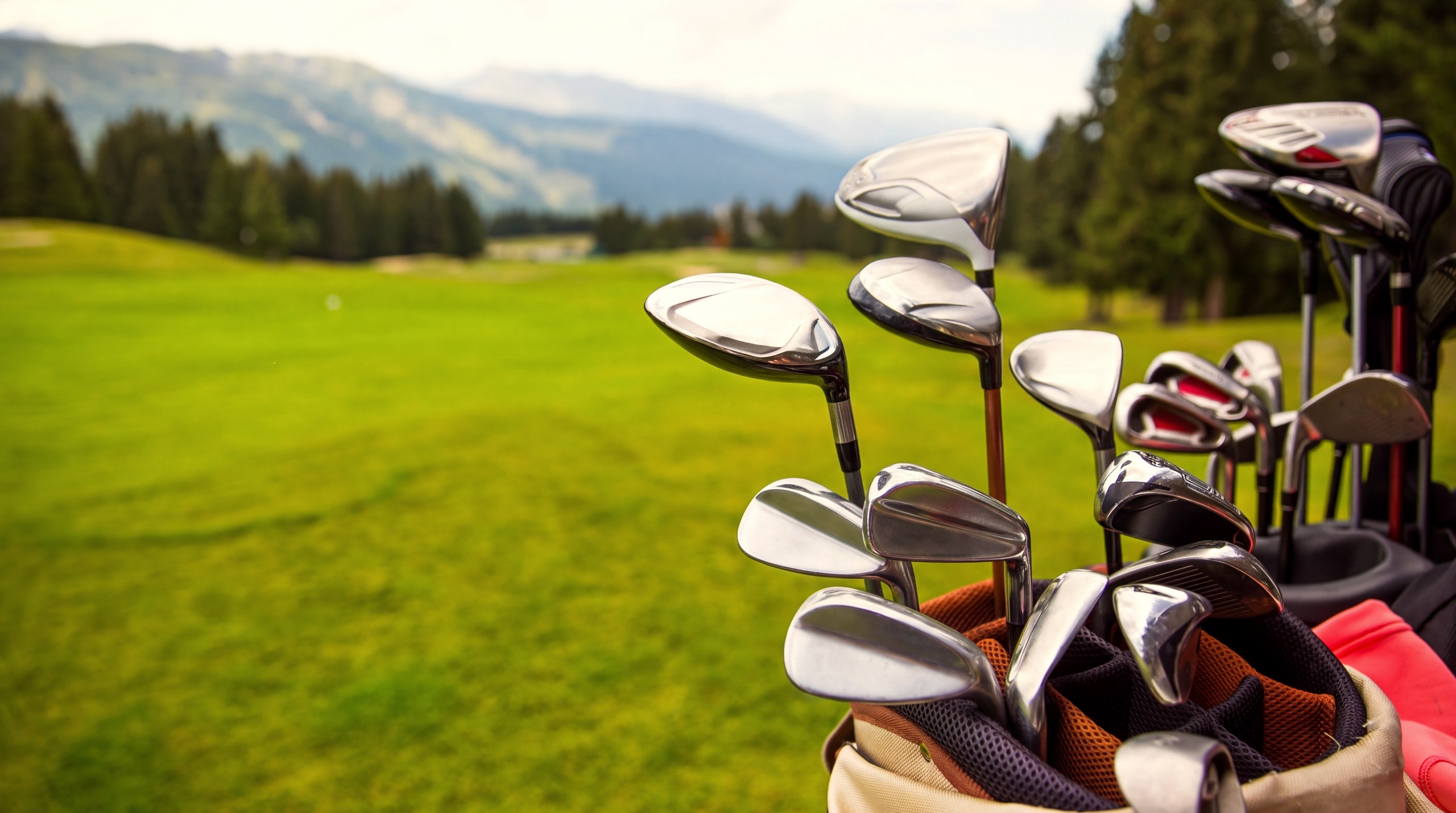 Un sac de golf posé sur un fairway du golf de Méribel, bordé de sapins
