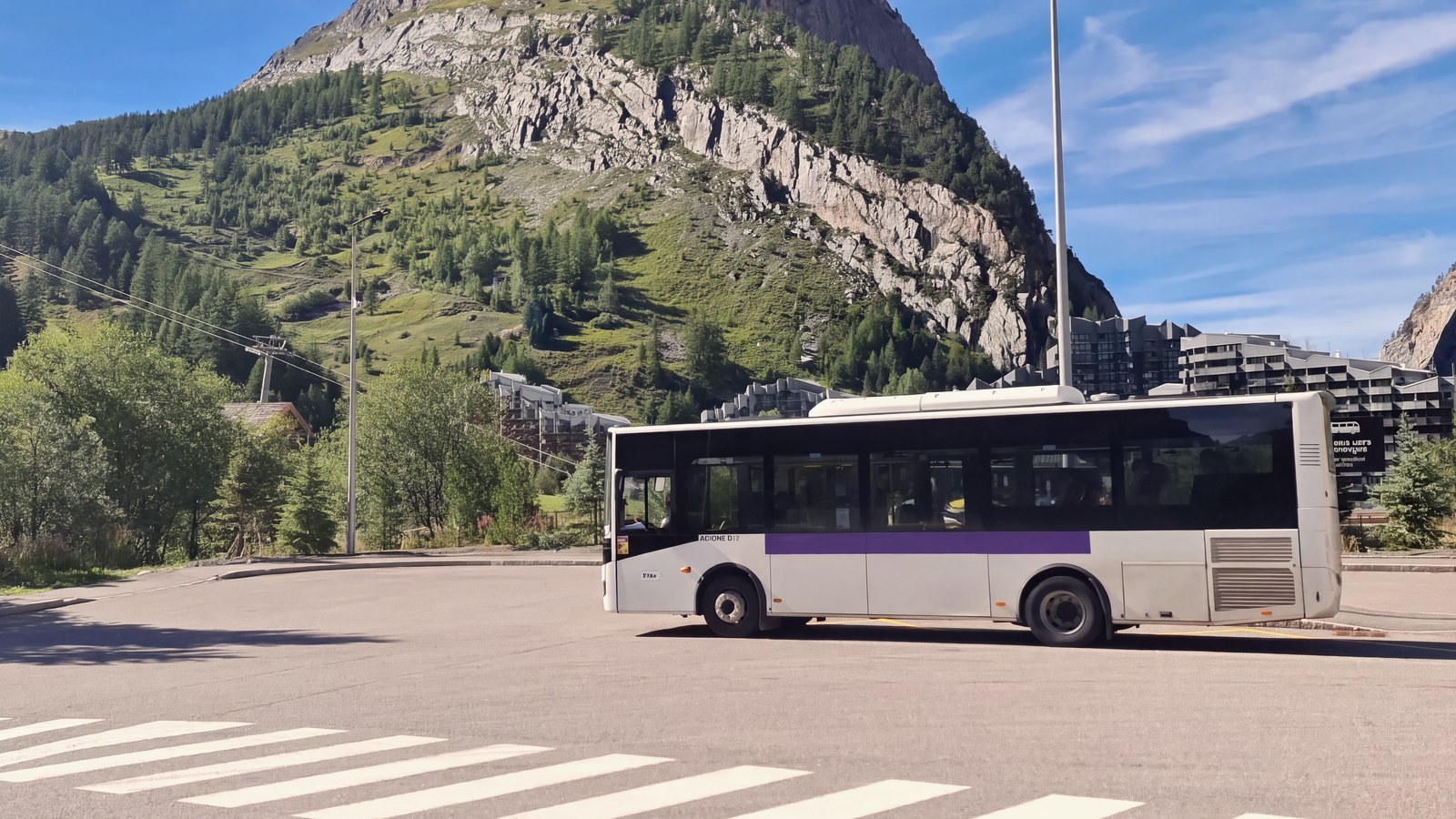 Le bus du Train violet, la navette gratuite entre Val d'Isère et Tignes, sur un parking de Val d'Isère en été