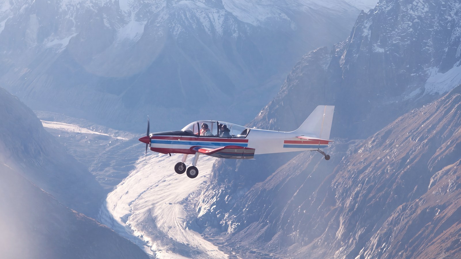 Un petit avion de tourisme en vol au-dessus de la Mer de Glace, dans le massif du Mont-Blanc